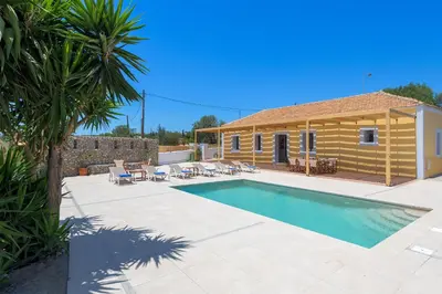 a swimming pool in front of a house at Villa Dorinna in Lachania
