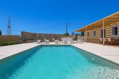 a swimming pool with chairs and a house at Villa Dorinna in Lachania