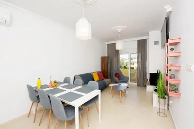 a white living room with a table and chairs at Naya Ixia Rhodes Apartment in Ixia