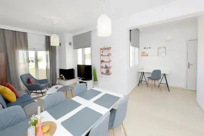 a living room with a blue table and chairs at Naya Ixia Rhodes Apartment in Ixia