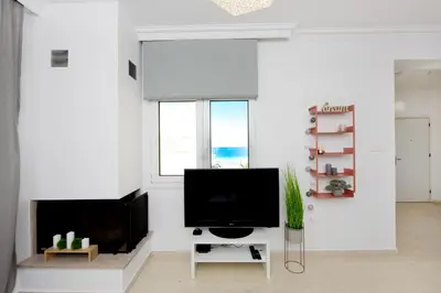 a living room with a television and a fireplace at Naya Ixia Rhodes Apartment in Ixia
