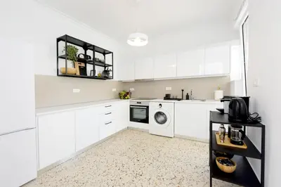 a kitchen with white cabinets and a washer and dryer at Naya Ixia Rhodes Apartment in Ixia
