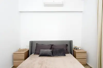 a bedroom with a bed and a white wall at Naya Ixia Rhodes Apartment in Ixia