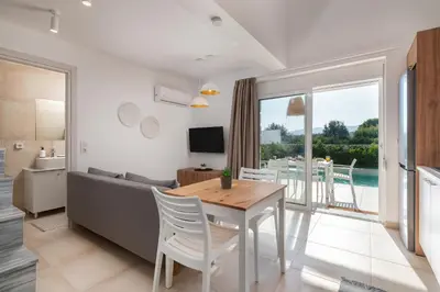 a living room with a table and a couch at New Loft by Ossiano Pool Villas, Heating Pool,2 min drive to Haraki Beach & 10 to Lindos in Haraki
