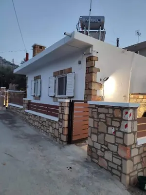 a house with a stone wall and a building at Villa Jimmy, Pilona Village in vlicha