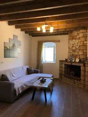 a living room with a couch and a fireplace at Villa Jimmy, Pilona Village in vlicha