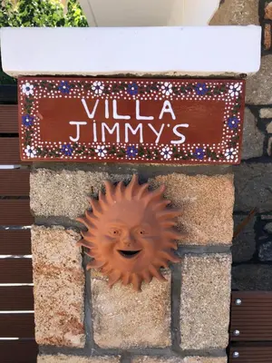 a smiley sun on a wall with a sign at Villa Jimmy, Pilona Village in vlicha