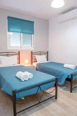 two beds in a room with towels on them at Stegna Holiday in Archangelos