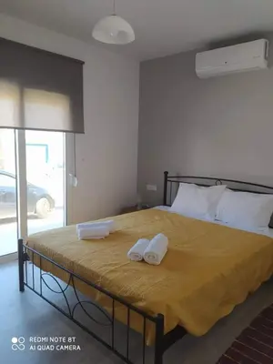 a bedroom with a bed with two towels on it at Stegna Holiday in Archangelos