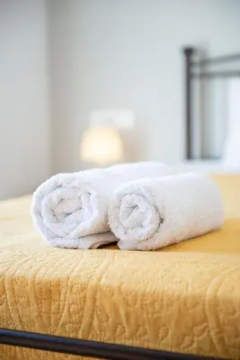 a stack of towels sitting on top of a bed at Stegna Holiday in Archangelos