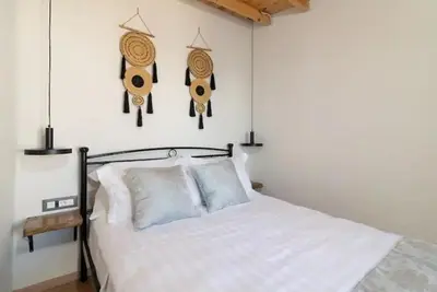 a bedroom with a white bed with drums on the wall at Kyrangelo Traditional House with outdoor jacuzzi in Koskinou