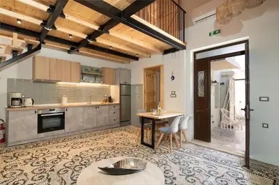a large kitchen with a table and chairs in it at Kyrangelo Traditional House with outdoor jacuzzi in Koskinou