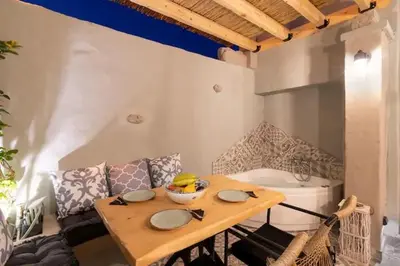 a table with a bowl of fruit on it in a kitchen at Kyrangelo Traditional House with outdoor jacuzzi in Koskinou