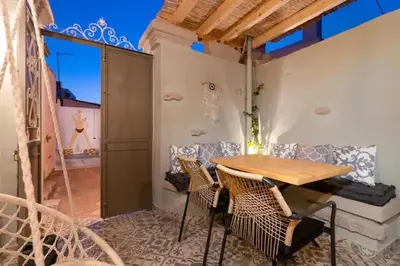 a table and chairs in a room with a balcony at Kyrangelo Traditional House with outdoor jacuzzi in Koskinou