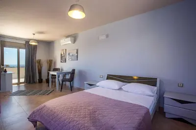 a bedroom with a bed and a dining room with a table at Des & Coo Luxury Villa with Private Pool in Faliraki