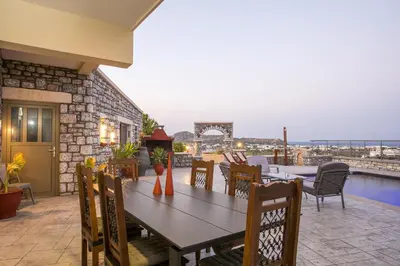 a wooden table and chairs on a patio with a view at Des & Coo Luxury Villa with Private Pool in Faliraki