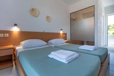 a bedroom with two beds with towels on them at Yiasemi Faliraki Rooms in Faliraki