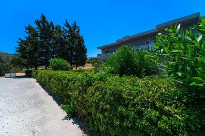 a hedge in front of a house at Yiasemi Faliraki Rooms in Faliraki