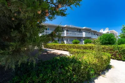 a large white building with a balcony at Yiasemi Faliraki Rooms in Faliraki