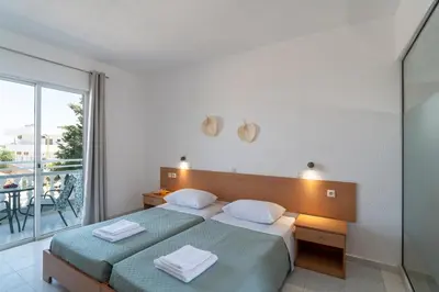 a bedroom with two beds and a balcony at Yiasemi Faliraki Rooms in Faliraki
