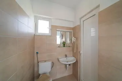 a bathroom with a toilet and a sink at Yiasemi Faliraki Rooms in Faliraki