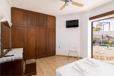 a bedroom with a bed and a tv and a table at House of Flowers in Rhodes Town