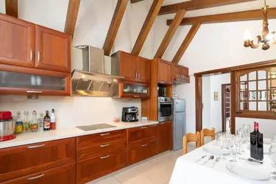 a kitchen with wooden cabinets and white counter tops at House of Flowers in Rhodes Town