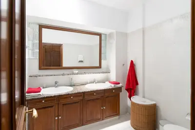 a bathroom with two sinks and a large mirror at House of Flowers in Rhodes Town
