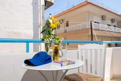 a table with a vase and a hat on a balcony at House of Flowers in Rhodes Town