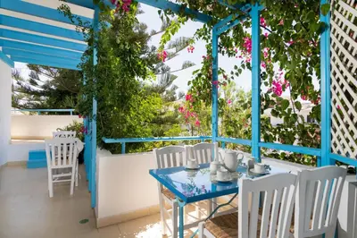 a blue table and chairs on a patio with flowers at House of Flowers in Rhodes Town