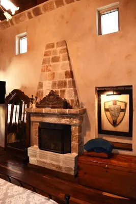 a living room with a stone fireplace in a room at The Dragon of Rodos in Rhodes Town
