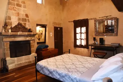 a bedroom with a bed and a fireplace at The Dragon of Rodos in Rhodes Town