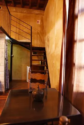 a dining room with a table and a spiral staircase at The Dragon of Rodos in Rhodes Town
