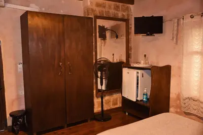 a bedroom with a bed and a dresser and a mirror at The Dragon of Rodos in Rhodes Town