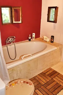 a bathroom with a white tub and a red wall at The Dragon of Rodos in Rhodes Town