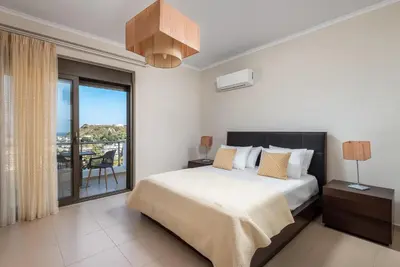 a bedroom with a bed and a balcony at Acro Villa in Afantou