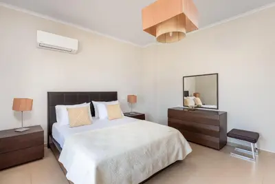 a bedroom with a large bed and a mirror at Acro Villa in Afantou