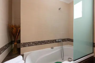 a bathroom with a bath tub with a glass shower door at Acro Villa in Afantou