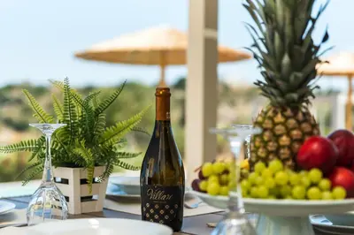 a bottle of wine sitting on a table with fruit at Acro Villa in Afantou