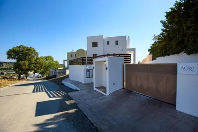a white house with a gate and a fence at Acro Villa in Afantou