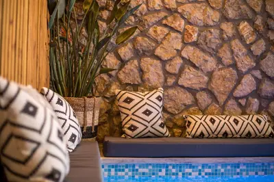 two pillows sitting on a table next to a stone wall at Demar luxury villa in Rhodes Town