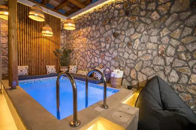 a swimming pool in a room with a stone wall at Demar luxury villa in Rhodes Town