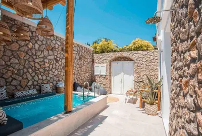 a house with a swimming pool and a stone wall at Demar luxury villa in Rhodes Town