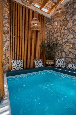 a swimming pool in a room with a stone wall at Demar luxury villa in Rhodes Town