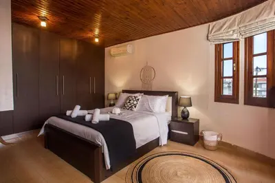 a bedroom with a large bed and a wooden ceiling at Villa Hriska in Ixia