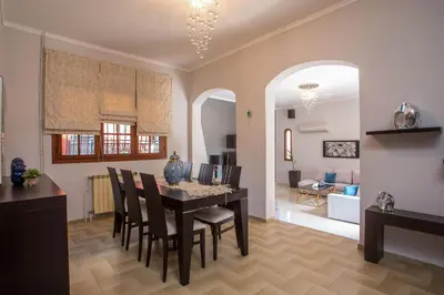 a dining room and living room with a table and chairs at Villa Hriska in Ixia
