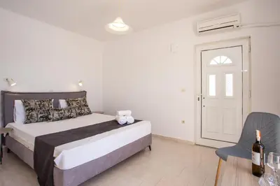 a bedroom with a bed and a table and a chair at Anastasia Private Pool Apartment in Afantou