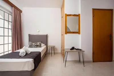 a bedroom with two beds and a mirror and a table at Anastasia Private Pool Apartment in Afantou