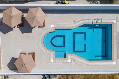 an overhead view of a swimming pool with umbrellas at Anastasia Private Pool Apartment in Afantou