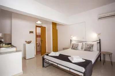 a bedroom with a bed and a kitchen in it at Anastasia Apartment in Afantou